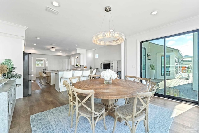 dining area featuring ornamental molding and dark hardwood / wood-style floors