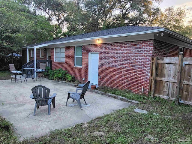 rear view of property featuring a patio and an outdoor fire pit