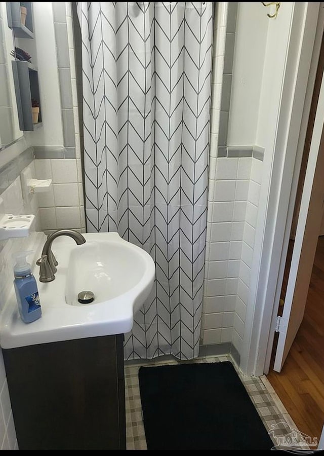 bathroom featuring tile walls, hardwood / wood-style floors, and vanity