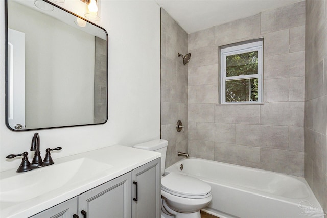 full bathroom with vanity, tiled shower / bath combo, and toilet