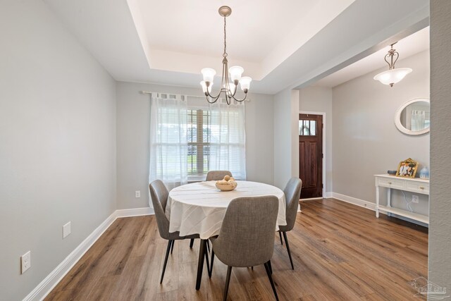 5726 Dunridge Dr, Pace, FL 32571 - dining area featuring wood finished floors, a raised ceiling, plenty of natural light, and a chandelier