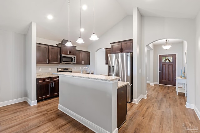 5726 Dunridge Dr, Pace, FL 32571 - kitchen featuring arched walkways, appliances with stainless steel finishes, dark brown cabinets, high vaulted ceiling, and recessed lighting