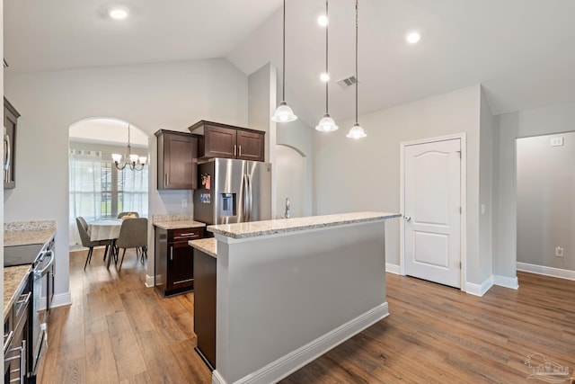 5726 Dunridge Dr, Pace, FL 32571 - kitchen with appliances with stainless steel finishes, arched walkways, dark brown cabinets, a chandelier, and wood finished floors