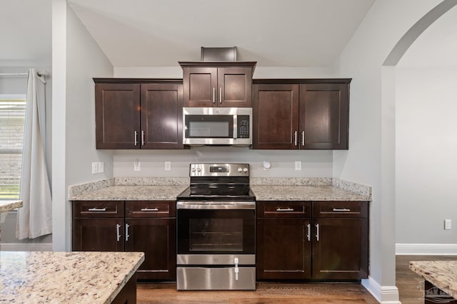5726 Dunridge Dr, Pace, FL 32571 - kitchen with stainless steel appliances, wood finished floors, arched walkways, and dark brown cabinetry
