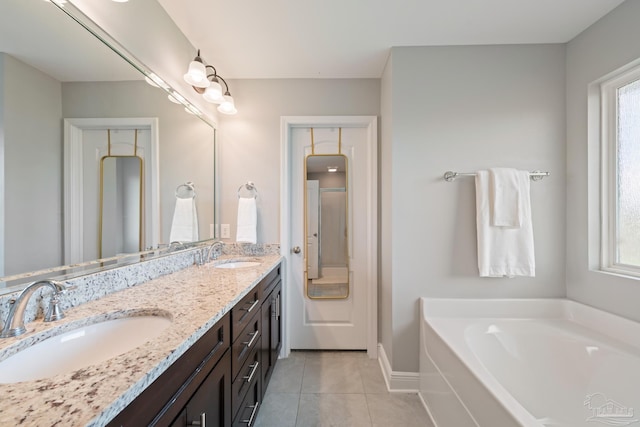 5726 Dunridge Dr, Pace, FL 32571 - full bath with tile patterned floors, a garden tub, double vanity, and baseboards
