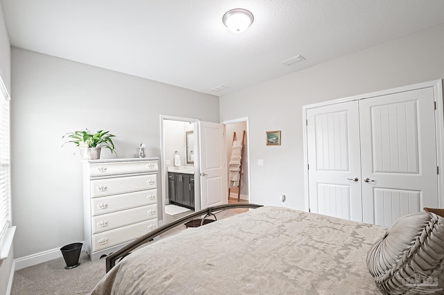 bedroom featuring light carpet, a closet, and ensuite bathroom