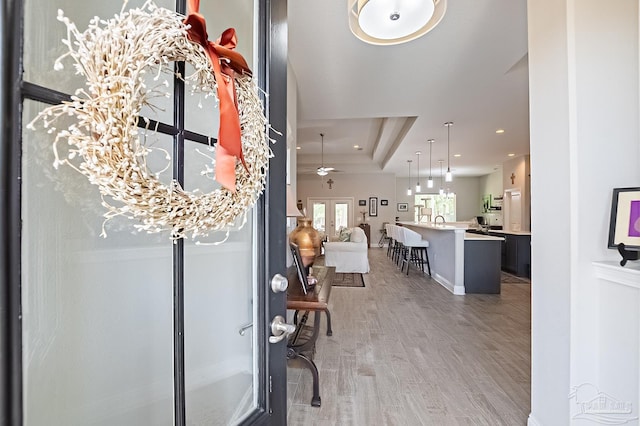 entryway featuring hardwood / wood-style flooring, ceiling fan, a raised ceiling, and french doors