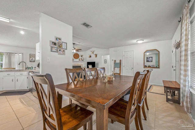 dining room with a textured ceiling, ceiling fan, visible vents, and light tile patterned floors
