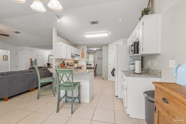 kitchen featuring open floor plan, light tile patterned floors, stainless steel appliances, and visible vents