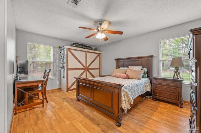 bedroom featuring multiple windows, visible vents, and light wood-type flooring