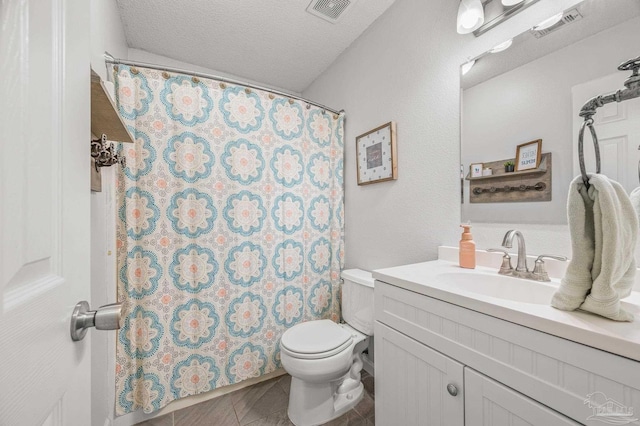 bathroom with visible vents, toilet, vanity, and a textured ceiling