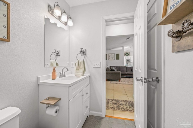 bathroom with toilet, vanity, tile patterned flooring, and visible vents