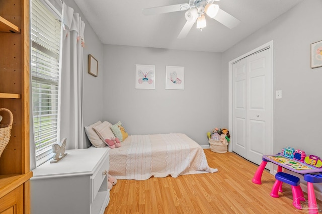 bedroom with light wood-style flooring, a closet, and ceiling fan