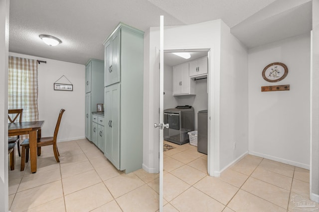 kitchen featuring independent washer and dryer, a textured ceiling, baseboards, and light tile patterned floors