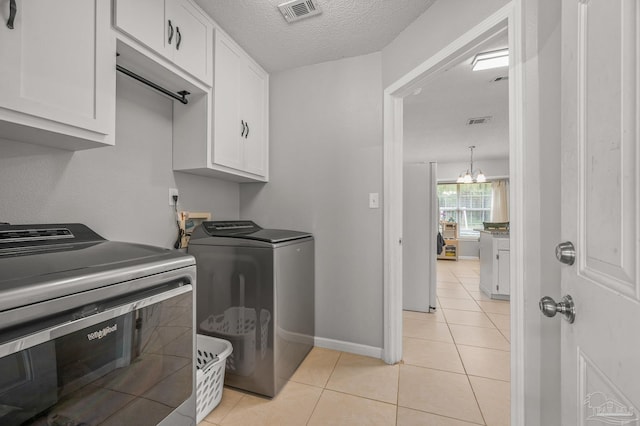 laundry room featuring light tile patterned flooring, cabinet space, visible vents, and independent washer and dryer