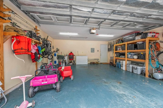 garage featuring a garage door opener, electric panel, and fridge
