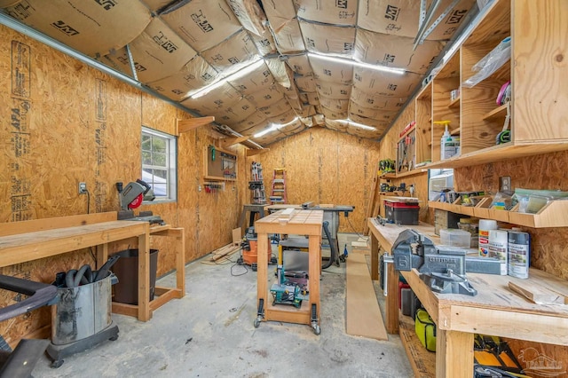 miscellaneous room featuring lofted ceiling, a workshop area, and concrete floors