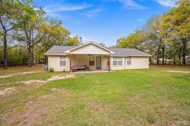 rear view of property featuring a patio, a lawn, roof with shingles, and a ceiling fan