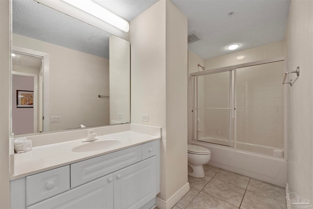 full bathroom featuring combined bath / shower with glass door, tile patterned floors, a textured ceiling, toilet, and vanity