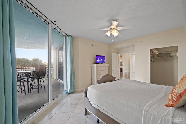 bedroom featuring access to exterior, ceiling fan, a textured ceiling, a closet, and light tile patterned flooring