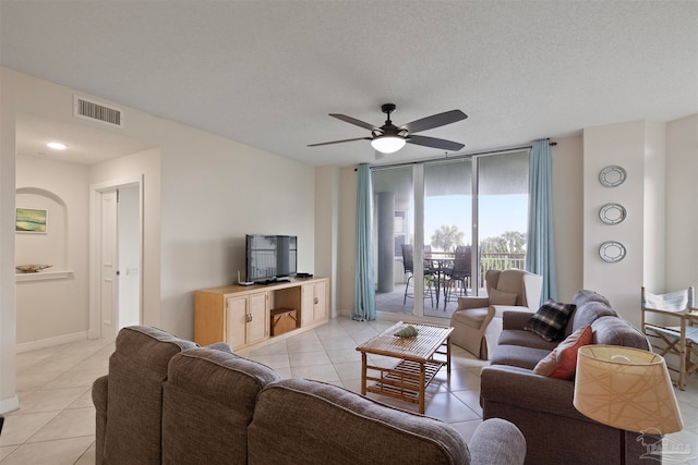 tiled living room with ceiling fan and a textured ceiling