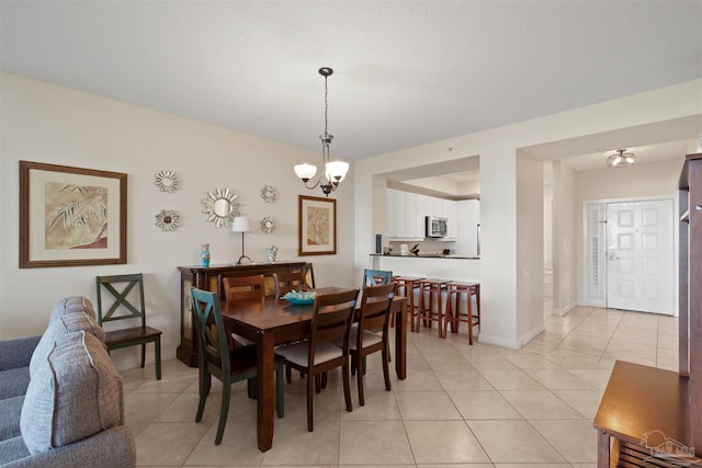 tiled dining room featuring an inviting chandelier