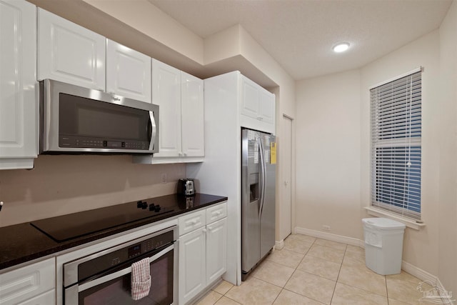 kitchen with light tile patterned floors, white cabinetry, and appliances with stainless steel finishes