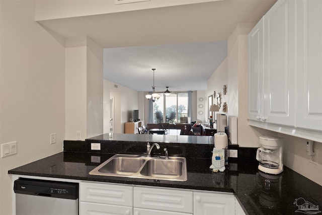 kitchen featuring dishwasher, sink, dark stone countertops, white cabinetry, and a chandelier