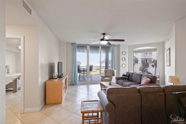 tiled living room with ceiling fan and a textured ceiling