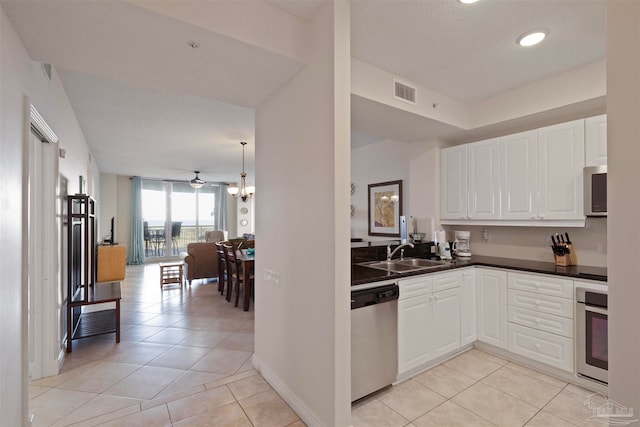 kitchen with stainless steel appliances, white cabinetry, ceiling fan, and sink