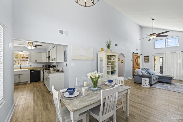 dining room featuring a barn door, light wood-style flooring, and a wealth of natural light