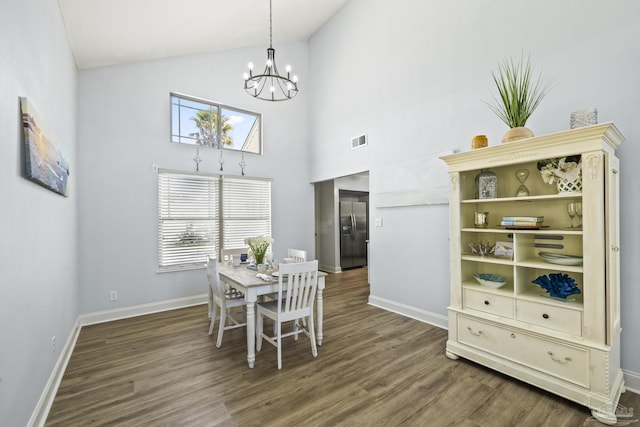 dining room featuring high vaulted ceiling, wood finished floors, visible vents, baseboards, and an inviting chandelier