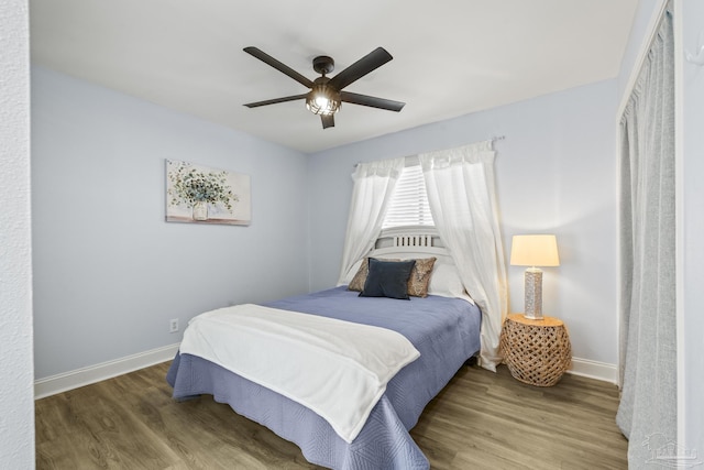 bedroom with ceiling fan, baseboards, and wood finished floors