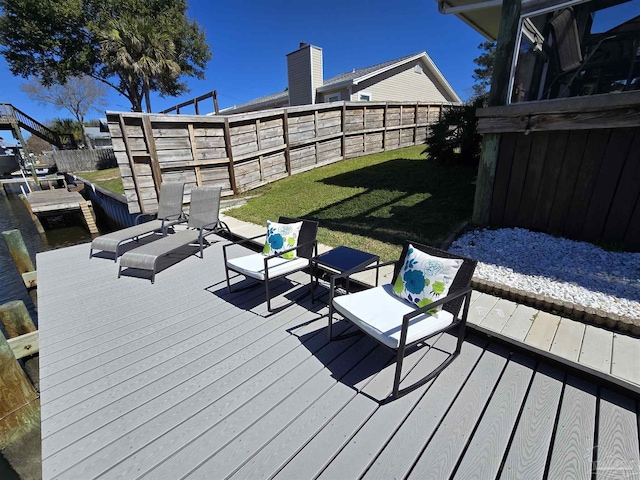 deck with a fenced backyard and a lawn