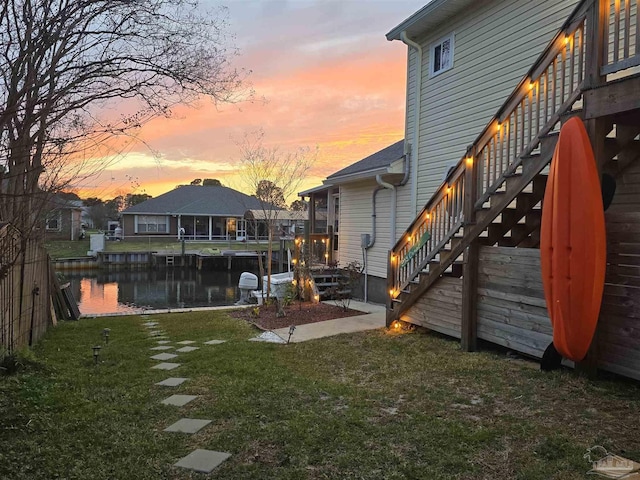 view of yard featuring a water view and stairway