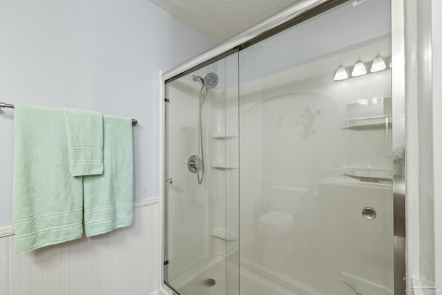 bathroom with a stall shower and a textured ceiling