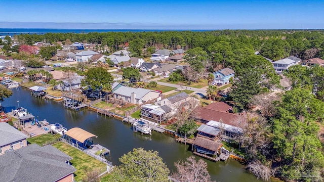 drone / aerial view with a residential view, a water view, and a view of trees