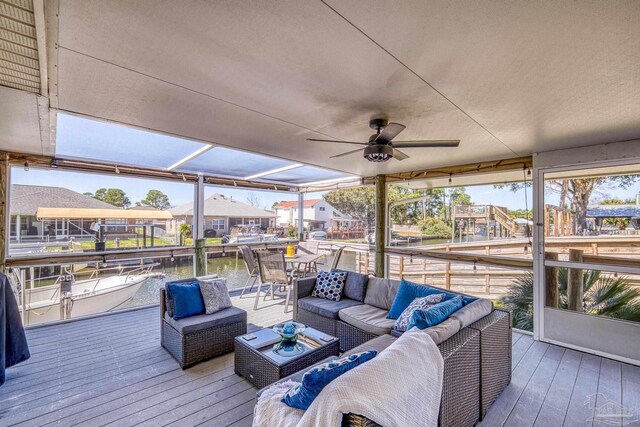 wooden terrace with outdoor lounge area and a ceiling fan