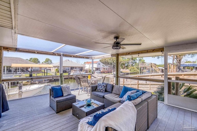 wooden deck with an outdoor living space and a ceiling fan