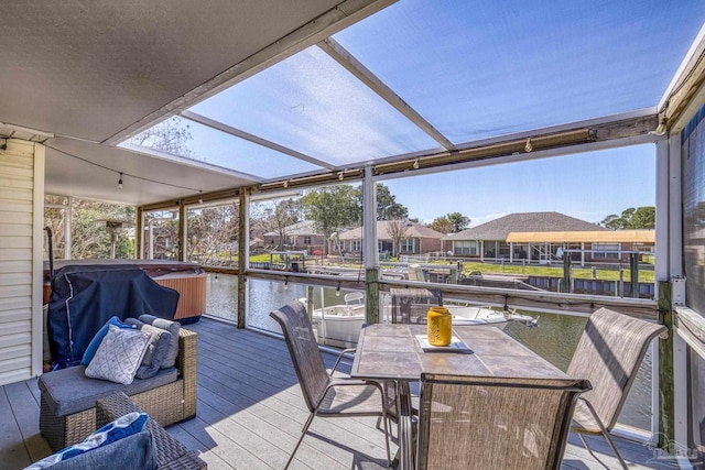 wooden deck featuring outdoor dining space, a water view, a hot tub, and grilling area