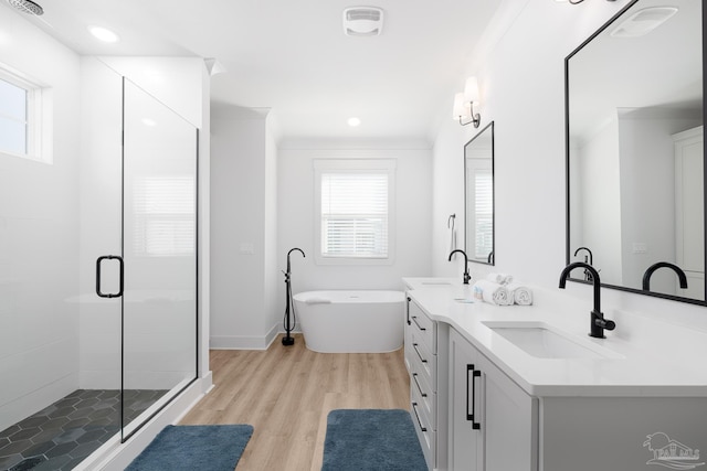 bathroom with hardwood / wood-style floors, vanity, crown molding, and shower with separate bathtub