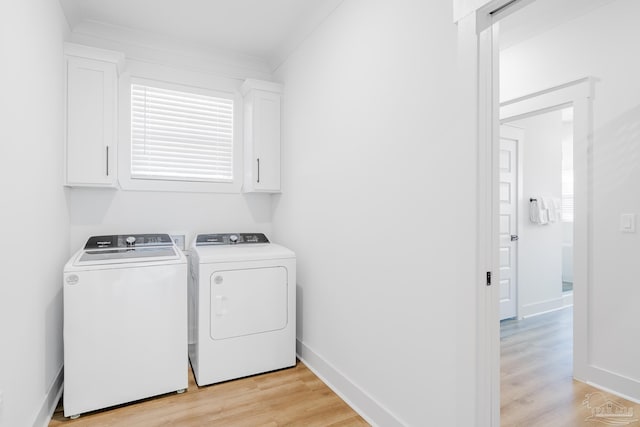 washroom featuring cabinets, light hardwood / wood-style flooring, washer and clothes dryer, and ornamental molding