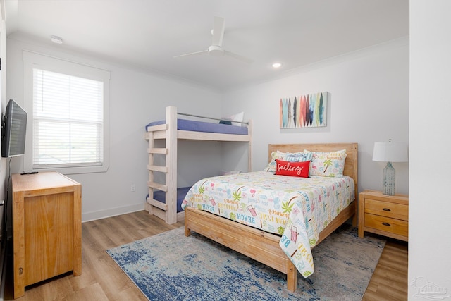 bedroom featuring ceiling fan, light wood-type flooring, and crown molding