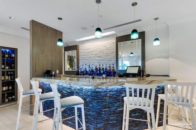 bar with light stone counters and hanging light fixtures