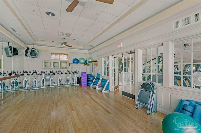 interior space featuring plenty of natural light, ceiling fan, french doors, and a tray ceiling