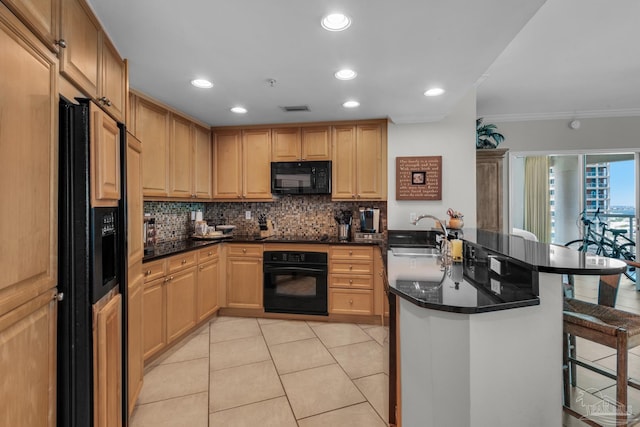 kitchen featuring black appliances, a breakfast bar, sink, kitchen peninsula, and ornamental molding