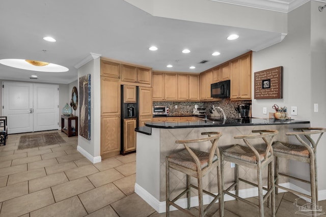 kitchen featuring light tile patterned flooring, decorative backsplash, ornamental molding, a kitchen bar, and kitchen peninsula