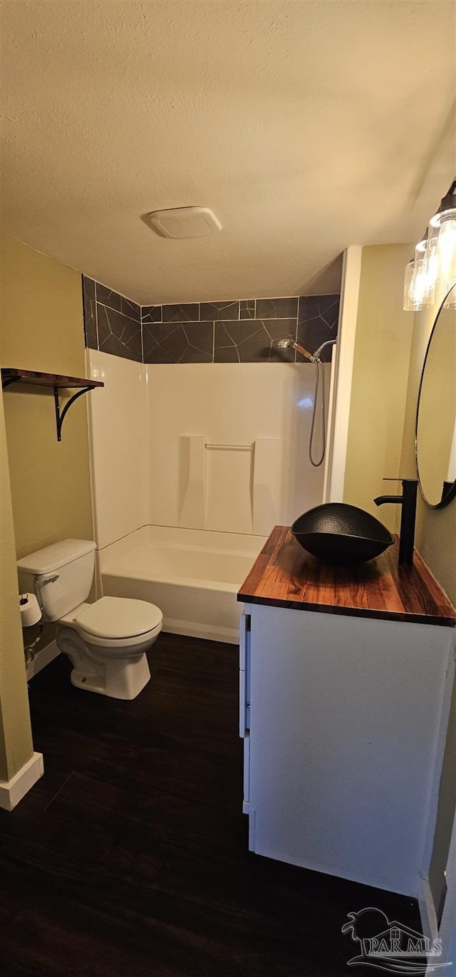 607 Hannah St, Pensacola, FL 32534 - bathroom featuring tub / shower combination, a textured ceiling, toilet, and wood finished floors