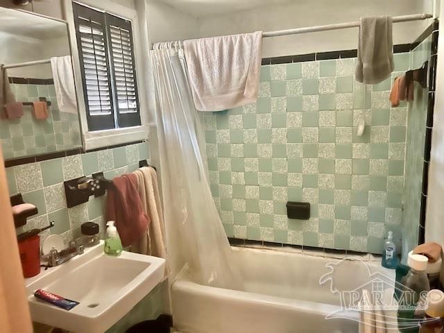 bathroom with sink, decorative backsplash, shower / bath combo, and tile walls