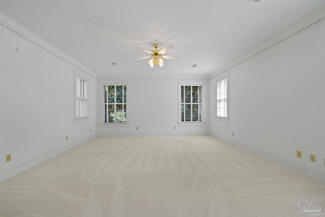 carpeted empty room featuring ceiling fan and crown molding